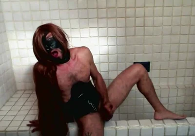 Long Hair Sissy in Corset Uses Gagball in Bathroom