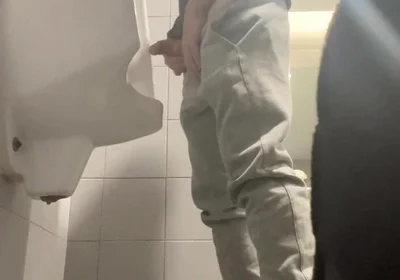 2 Boys in Sneakers Having Fun at Public Toilets' Urinal